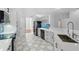 Updated kitchen with white cabinetry, new appliances, and tiled floor overlooking living area at 1851 Sweetwater West Cir, Apopka, FL 32712