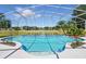 Inviting screened-in pool area with clear blue water, and beautiful landscaping at 1851 Sweetwater West Cir, Apopka, FL 32712