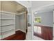 View of walk-in closet through mirrored sliding doors from main bedroom with hardwood floors at 1851 Sweetwater West Cir, Apopka, FL 32712