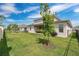 Well-maintained backyard featuring green grass, a young tree, and covered patio, perfect for outdoor activities at 19334 Banfield Pl, Orlando, FL 32827