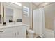 Bathroom with white cabinets, a bathtub with a shower, and a window at 19334 Banfield Pl, Orlando, FL 32827