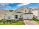 Charming two-story home with a well-manicured lawn, colorful shutters, and a brick driveway at 19334 Banfield Pl, Orlando, FL 32827