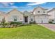 Charming two-story home featuring a well-manicured lawn, beautiful landscaping, and a three-car garage at 19334 Banfield Pl, Orlando, FL 32827