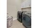 Well-equipped laundry room with modern washer and dryer and white cabinets for ample storage at 19334 Banfield Pl, Orlando, FL 32827