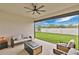 Relaxing covered patio with sleek furniture, ceiling fan, and views of the manicured backyard at 19334 Banfield Pl, Orlando, FL 32827
