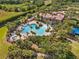 Beautiful aerial view of the community pool and clubhouse featuring resort style pool and spa surrounded by palm trees at 1945 Via Lago Dr, Lakeland, FL 33810