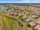 Expansive aerial shot showcasing residential homes with terracotta roofs in a well-planned community close to a lake at 1945 Via Lago Dr, Lakeland, FL 33810