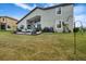 Large grassy backyard with a patio seating area, beautiful landscaping, and grill at 1945 Via Lago Dr, Lakeland, FL 33810