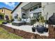 Spacious backyard patio with comfortable seating, lush landscaping, and an outdoor grill at 1945 Via Lago Dr, Lakeland, FL 33810