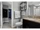 This is a bathroom with a dark vanity with granite countertop, white fixtures, and a shower with a rainfall head at 1945 Via Lago Dr, Lakeland, FL 33810