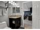 This is a bathroom with a dark vanity with granite countertop, white fixtures, and a view into the living area at 1945 Via Lago Dr, Lakeland, FL 33810