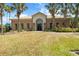 Exterior of a community clubhouse surrounded by palm trees and tropical landscaping at 1945 Via Lago Dr, Lakeland, FL 33810