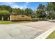 Community entrance sign with manicured landscaping and a paved brick entrance at 1945 Via Lago Dr, Lakeland, FL 33810