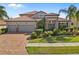 Beautiful home with a tile roof, brick driveway and tropical landscaping in the front yard at 1945 Via Lago Dr, Lakeland, FL 33810