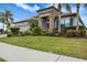 Beautiful home with a tile roof, well-manicured lawn and tropical landscaping in the front yard at 1945 Via Lago Dr, Lakeland, FL 33810