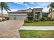 Beautiful home with a tile roof, brick driveway and tropical landscaping in the front yard at 1945 Via Lago Dr, Lakeland, FL 33810