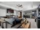 This is a living room with a comfortable gray sofa, a ceiling fan, and built in cabinets with a sink at 1945 Via Lago Dr, Lakeland, FL 33810