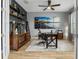 Home office with dark wood furniture, stylish shelves, and a large beach-themed art piece at 1945 Via Lago Dr, Lakeland, FL 33810