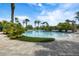 Large community pool surrounded by palm trees and lush tropical plants, perfect for relaxation at 1945 Via Lago Dr, Lakeland, FL 33810