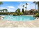 Beautiful pool with lush landscaping, palm trees, and comfortable seating areas, ideal for relaxation at 1945 Via Lago Dr, Lakeland, FL 33810
