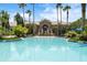 Beautiful community pool area with clear water, palm trees, and a luxurious clubhouse in the background at 1945 Via Lago Dr, Lakeland, FL 33810