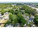 An aerial view showcasing residences with pools surrounded by lush green trees, near a commercial area at 226 S Apollo Dr, Apopka, FL 32703