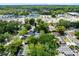 Aerial view of a neighborhood showing rooftops, trees, pools, and nearby commercial establishments along a busy street at 226 S Apollo Dr, Apopka, FL 32703