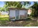 Exterior view of a weathered storage shed in the backyard with some foliage growing on the sides at 226 S Apollo Dr, Apopka, FL 32703
