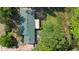 Aerial view of a green roof and backyard with lush trees and access to a lake at 228 Deleon Rd, Debary, FL 32713