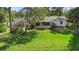 A spacious backyard featuring a lush green lawn, screened lanai, and mature trees at 228 Deleon Rd, Debary, FL 32713