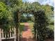 Charming backyard entrance with flowering archway, leading to a beautifully landscaped yard at 228 Deleon Rd, Debary, FL 32713