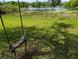 Backyard view with a swing near a pond, offering peaceful relaxation by the water at 228 Deleon Rd, Debary, FL 32713