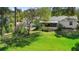 Expansive backyard with mature trees, patio, and screened in lanai, offering a serene outdoor space at 228 Deleon Rd, Debary, FL 32713