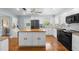 Bright kitchen with white cabinets, wood island top, black appliances, and wood flooring at 228 Deleon Rd, Debary, FL 32713