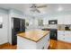 Well-lit kitchen with white cabinets, butcher block island, and stainless steel appliances at 228 Deleon Rd, Debary, FL 32713