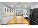 Bright kitchen with a butcher block island, white cabinets and shelving, and an open dining area at 228 Deleon Rd, Debary, FL 32713