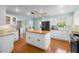 Open kitchen with white cabinets, stainless steel appliances, tile backsplash, and wood flooring at 228 Deleon Rd, Debary, FL 32713