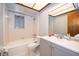 Bright bathroom showcasing tiled walls, a tub, and a gray vanity with ample counter space at 2411 Trafalgar Dr, Orlando, FL 32837
