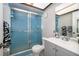 Bathroom featuring a blue tiled shower with a glass door and gray vanity at 2411 Trafalgar Dr, Orlando, FL 32837