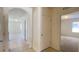 The hallway showcases neutral tile flooring, two doors and the entrance into a carpeted bedroom at 271 Tanglewood Dr, Davenport, FL 33896