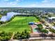 Aerial view of community recreational facilities: soccer field, covered picnic area, and a basketball court near a pond at 2764 W Covington Dr, Deltona, FL 32738