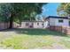 Large, grassy backyard featuring a wooden fence and mature shade trees at 2903 E Michigan St, Orlando, FL 32806