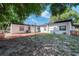 Backyard featuring a mulched area, grass, and exterior of the home at 2903 E Michigan St, Orlando, FL 32806
