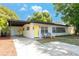 Charming single story home featuring a covered carport, manicured lawn, and bright yellow doors at 2903 E Michigan St, Orlando, FL 32806