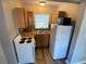 Bright kitchen features wood cabinets, white appliances, and a double sink under a window at 2903 E Michigan St, Orlando, FL 32806