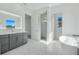 Bright bathroom features modern vanity, large mirror, and separate room with soaking tub at 3024 Kensington Ave, Davenport, FL 33837