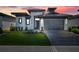 Stunning home with a modern design, featuring stone accents, a well-manicured lawn, and a sleek garage door at 3024 Kensington Ave, Davenport, FL 33837