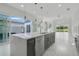 Open kitchen with a large island and bar seating offering seamless indoor/outdoor living at 3024 Kensington Ave, Davenport, FL 33837