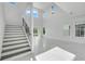 Bright living room features a modern staircase, soaring ceilings, and large windows for natural light at 3024 Kensington Ave, Davenport, FL 33837
