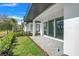 Covered back patio has paver flooring, trimmed landscape beds and a view of mature palm trees at 3024 Kensington Ave, Davenport, FL 33837